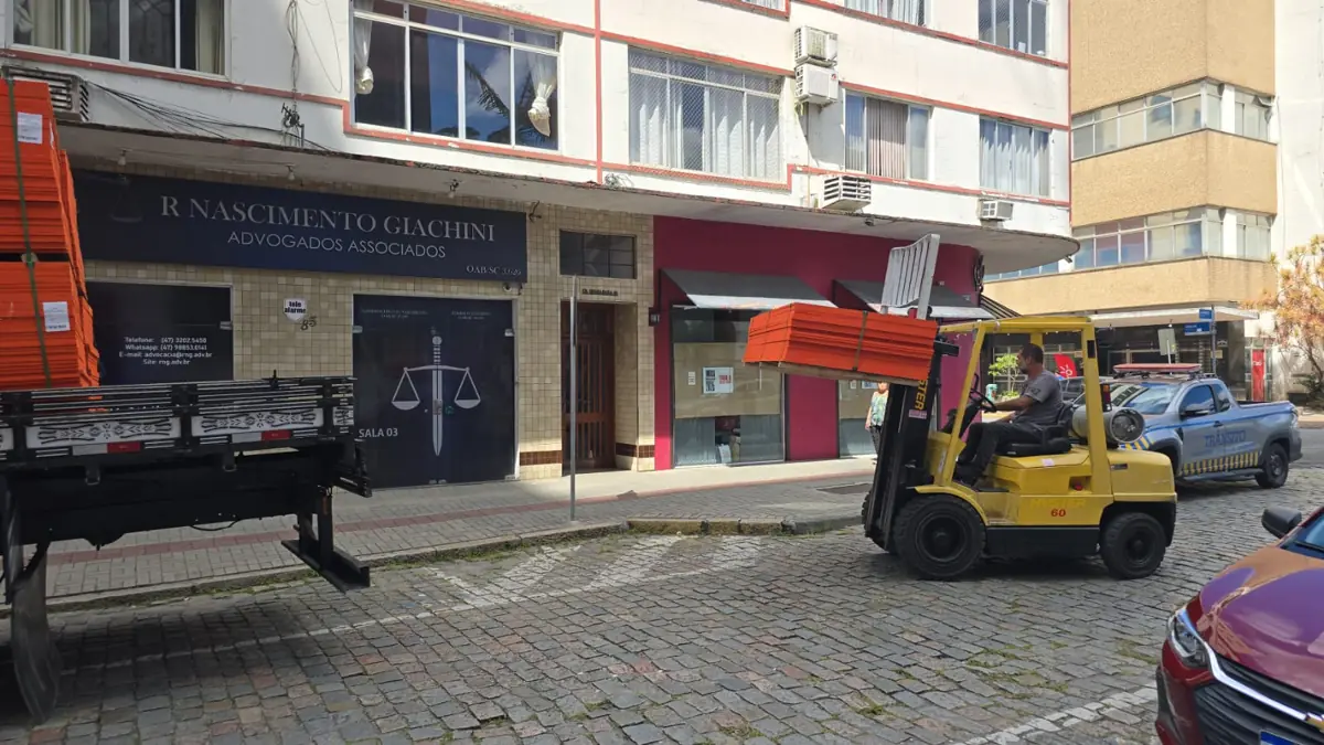 Operador do Xande descarregando material com empilhadeira em rua do Centro de Joinville
