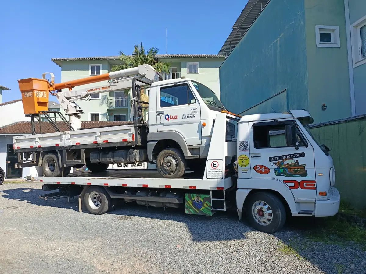 Guincho plataforma transportando caminhão com cesto aéreo em Joinville