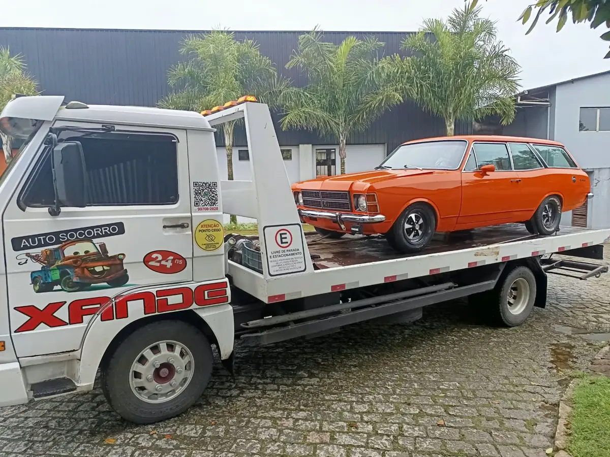 Guincho plataforma do Xande transportando uma Chevrolet Caravan clássica laranja