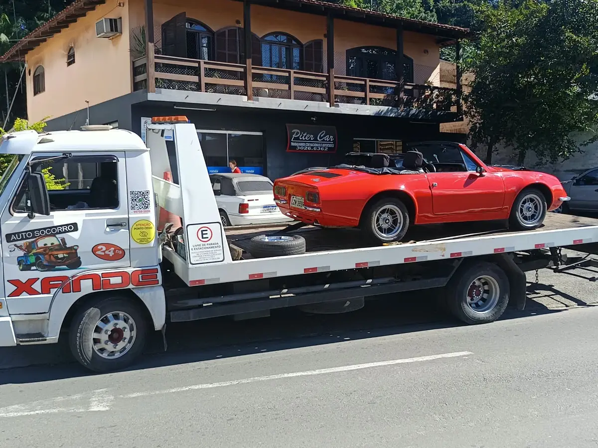 Puma conversível vermelho transportado em guincho plataforma
