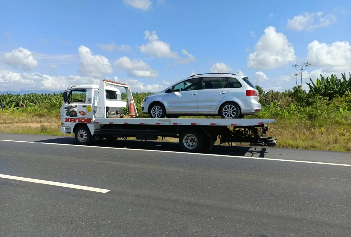 Guincho plataforma Xande com carro prata em rodovia na região de Joinville