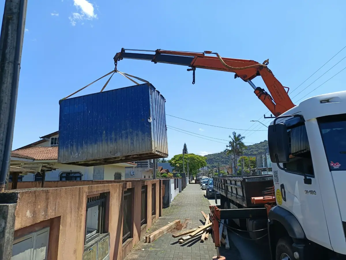Munck içando container de obra sobre muro em rua de Joinville