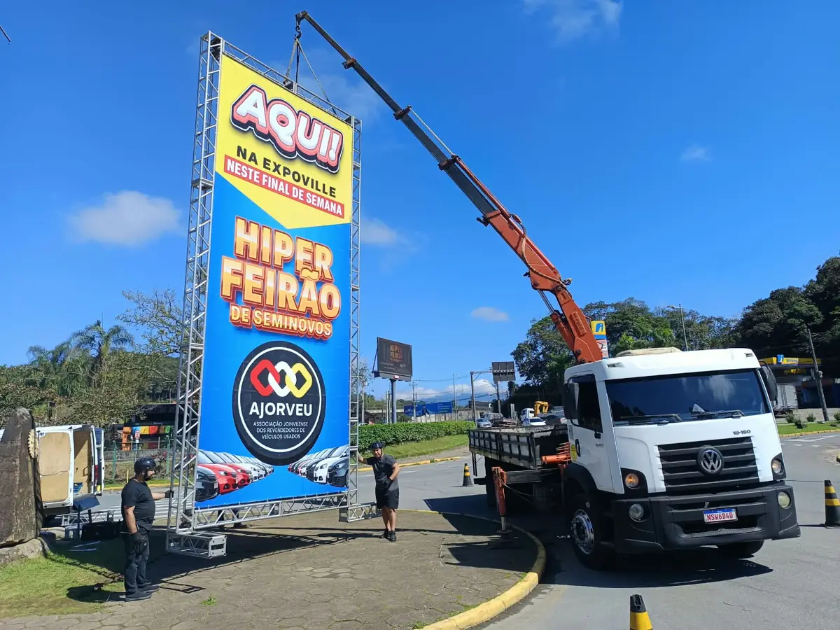 Munck erguendo painel de evento em estrutura de treliça na Expoville, Joinville