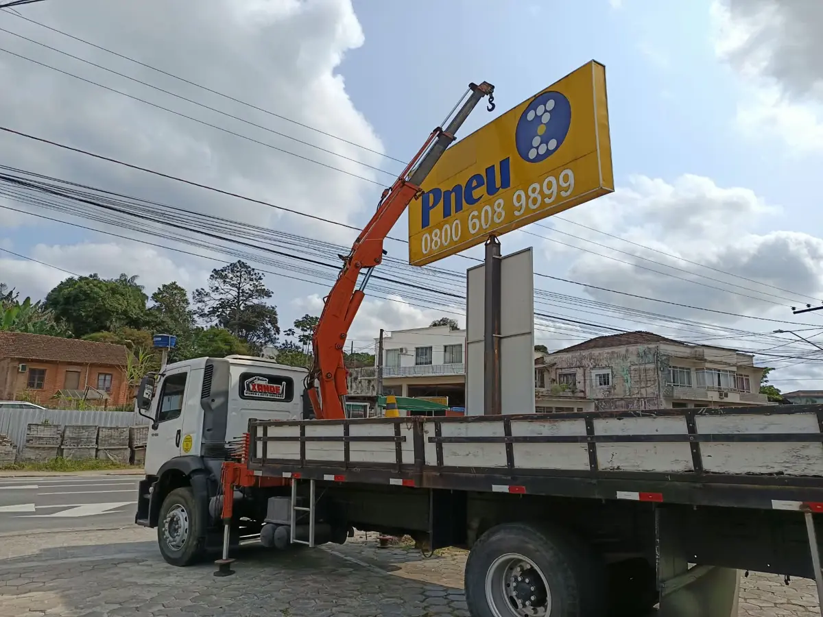 Caminhão munck do Xande trabalhando em placa luminosa de loja de pneus em Joinville