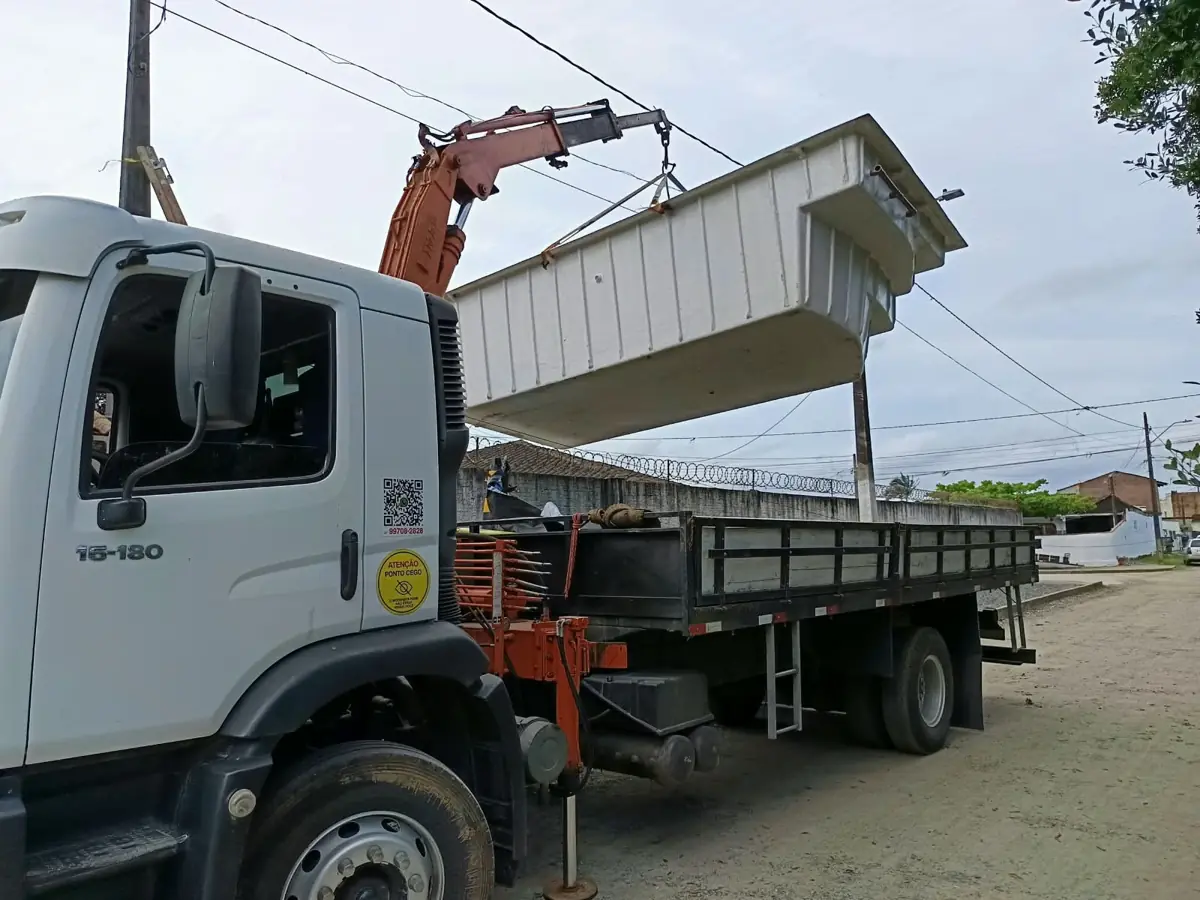 Caminhão munck do Xande içando piscina de fibra branca para transporte